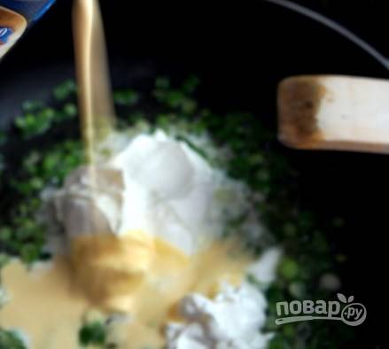 Добавьте зеленый лук к маслу, затем — сметану и сырный соус.