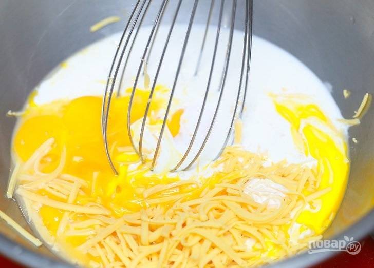4. Соедините взбитые яйца, сливки и половину тертого сыра. Перемешайте и прогрейте на огне, постоянно помешивая. 