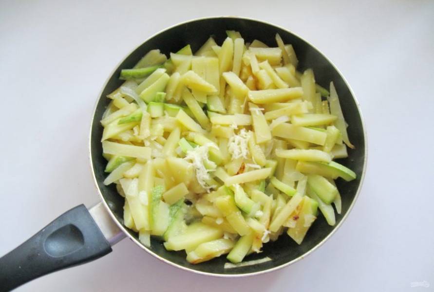 Посолите овощи по вкусу и накройте крышкой. Жарьте до полной готовности еще 7-8 минут.  Затем добавьте измельченный чеснок.