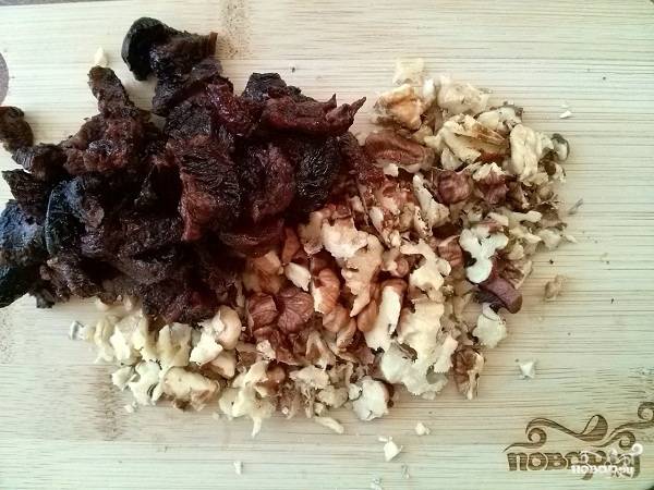 Затем добавьте овсяно-ореховую муку и перемешайте.
Оставшиеся чернослив и орехи мелко порежьте и добавьте к тесту.