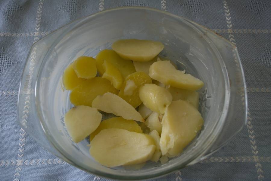 Форму для запекания или кастрюльку из огнепрочного стекла смазать маслом. Выложить слой картофеля.