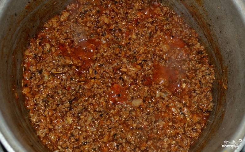 Предварительно отварите макароны в кипящей подсоленной воде. Фарш пропускаем через мясорубку вместе с луком. Обжариваем фарш на растительном масле 4-5 минут, добавляем томатную пасту и обжариваем до полной готовности фарша.