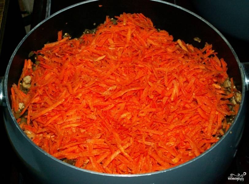 3. Морковь очистите, натрите на средней терке и добавьте в кастрюлю к баклажанам.