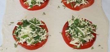 На помидоры уложите тертый сыр и зелень.
