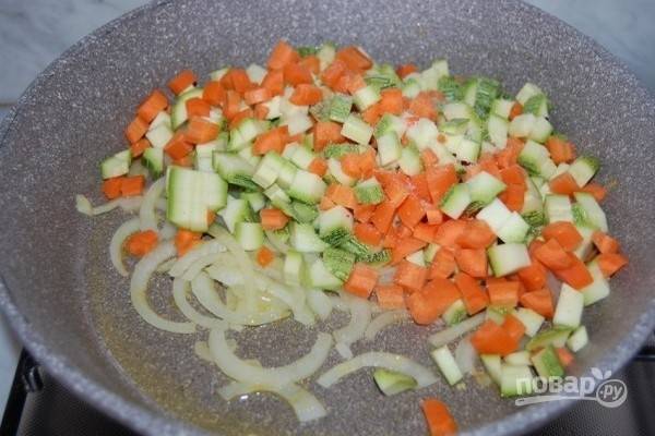 2.	На раскаленном оливковом масле, обжарьте лук нарезанный полукольцами. Добавьте морковь и цуккини.