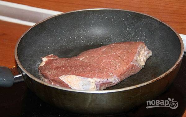 Раскалите на плите сухую сковородку и обжарьте на ней все куски мяса с обеих сторон буквально по одной минутке, чтобы говядина приобрела золотистый цвет. 