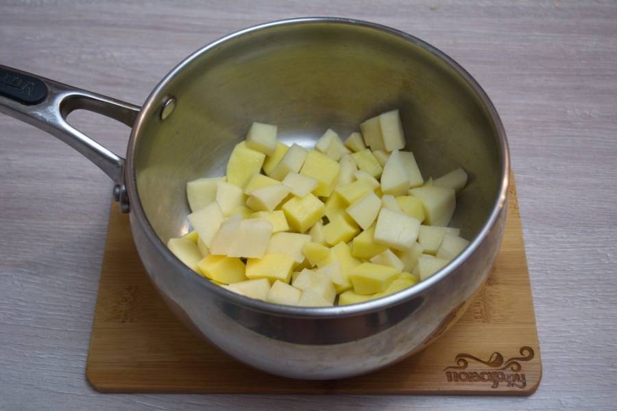 1. Очистите картофель от шкурки.  Нарежьте его на кубики. Для приготовления супа можно взять молодой картофель. Он тоже отлично подойдет для приготовления такого супа. Залейте картофель водой, поставьте вариться на среднем огне (время варки — 10 минут).