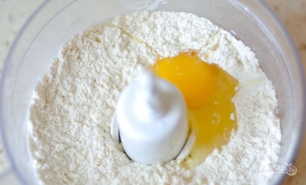 Для теста в чашу блендера поместите просеянную муку, нарезанное холодное сливочное масло, 1/3 стакана сахара, по щепотке ванилина и разрыхлителя. Вбейте сырое куриное яйцо и превратите все в однородную массу. 