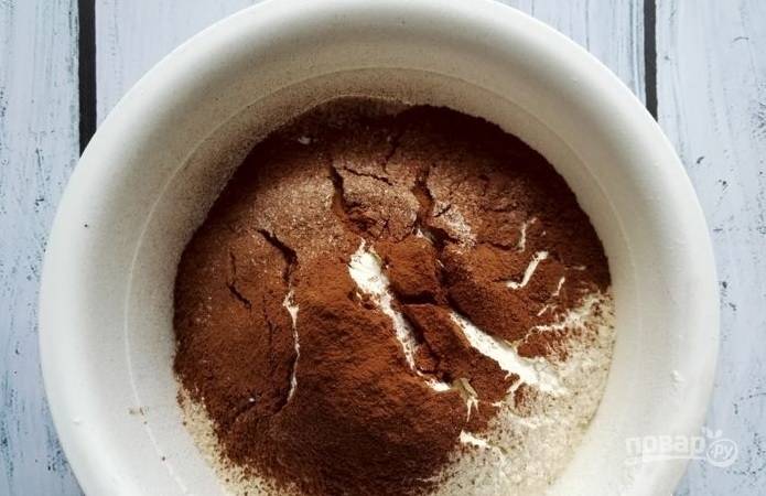 Сначала сделайте тесто. В глубокой миске смешайте сахар, разрыхлитель и соду. Затем просейте какао и муку. Перемешайте.