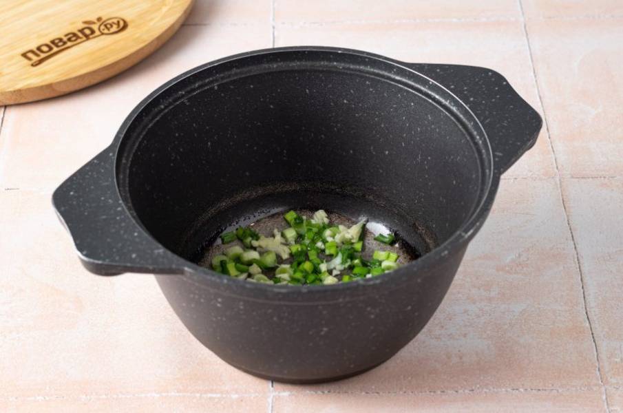Разогрейте в кастрюле небольшое количество кунжутного масла и обжарьте 30-50 секунд измельченный чеснок с зеленым луком.