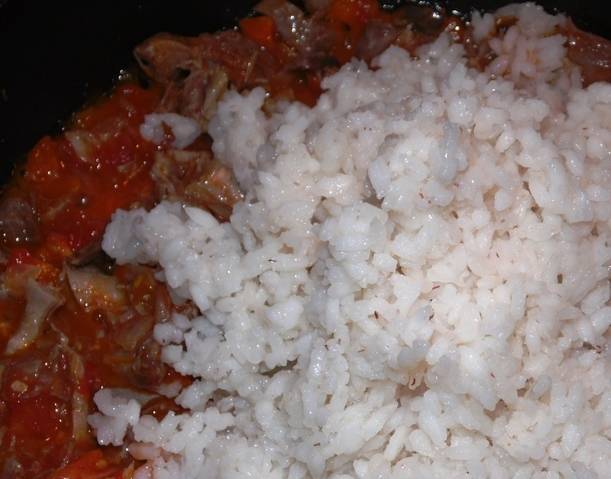 Затем добавьте порезанные помидоры, рис и мясо, посолите, поперчите и немного протушите. 
