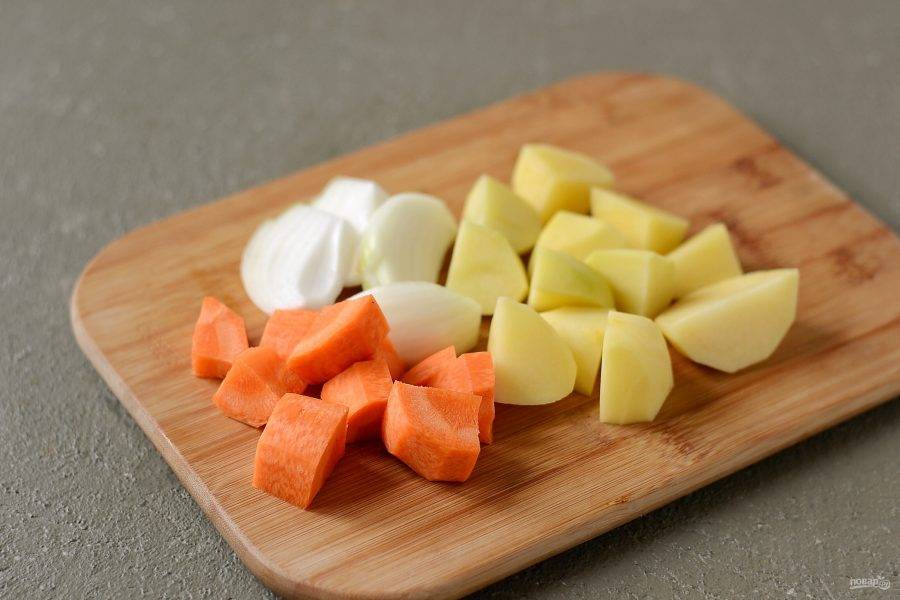 Картофель и морковь помойте, очистите от кожуры, нарежьте крупными ломтиками. Лук нарежьте на четвертинки.