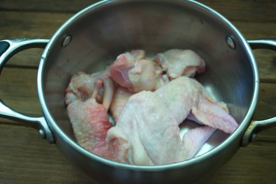 Куриные крылья нарезать произвольно. Целое крыло в супе неудобно кушать. Я их поделила на 2-3 части каждое. Залейте крылья водой и поставьте вариться. 