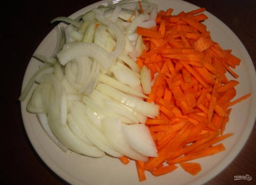 2.	Чищу луковицу и морковку, нарезаю лук полукольцами, а морковь — соломкой. Обжариваю овощи до мягкости на отдельной сковороде.