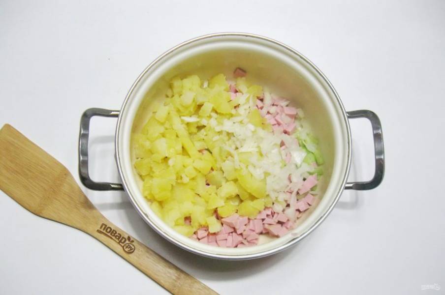 Картофель сварите, охладите и очистите. Нарежьте мелко и выложите в кастрюлю. Добавьте нарезанный лук.