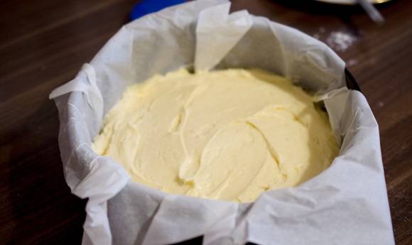 2. Форму для запекания смажьте немного сливочным маслом и застелите бумагой. Выложите тесто, разровняйте его. 