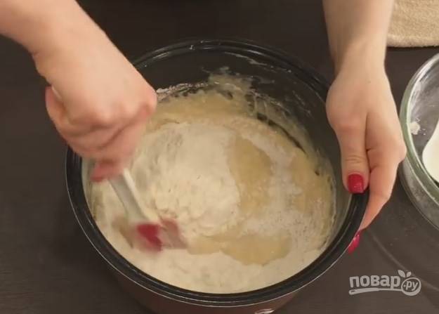 8. Введите в тесто оставшуюся муку. Тесто должно быть густое, как на оладьи. После этого добавьте подсолнечное масло. Мешайте лопаткой или руками. Тесто будет липнуть к ним. 