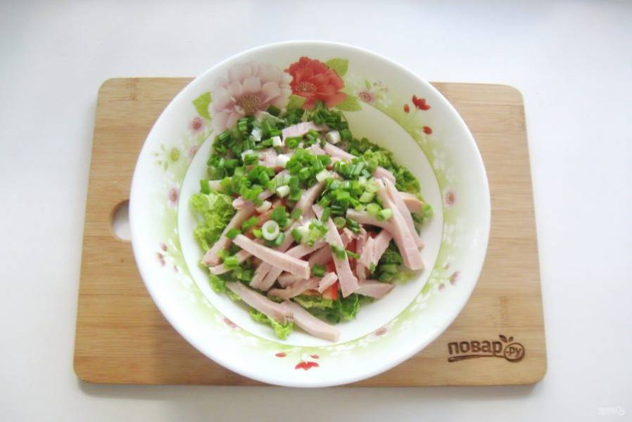 Зеленый лук мелко нарежьте и добавьте в салат.