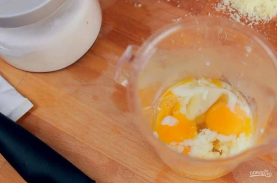 3. Достаньте яйца и разбейте в стакан. Добавьте к ним горчицу, соль, перец, лимонный сок и снова хорошо взбейте. Добавьте немного тертого пармезана. Не прекращая взбивать, добавьте 100 мл оливкового масла.