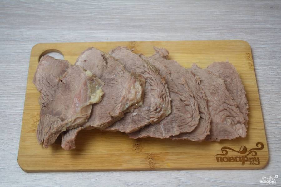 Отварное мясо нужно остудить и нарезать острым ножом на пластины.