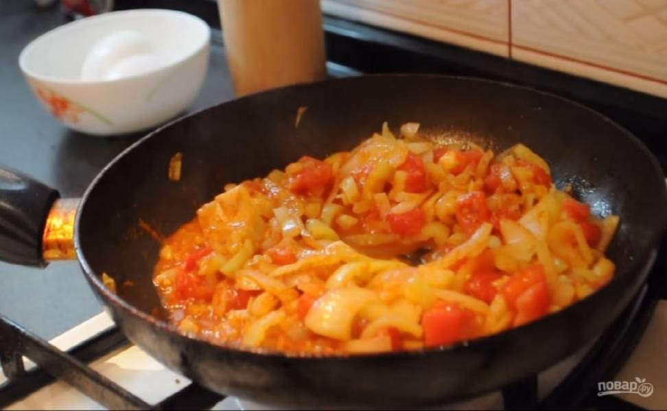 2. Когда перец слегка обжарится, добавьте нарезанные небольшими кусочками помидоры (можете снять с них шкурку по желанию). Обжарьте овощи примерно 5 минут, после чего посолите, поперчите и добавьте специи по вкусу. Хорошо перемешивайте овощи во время приготовления.