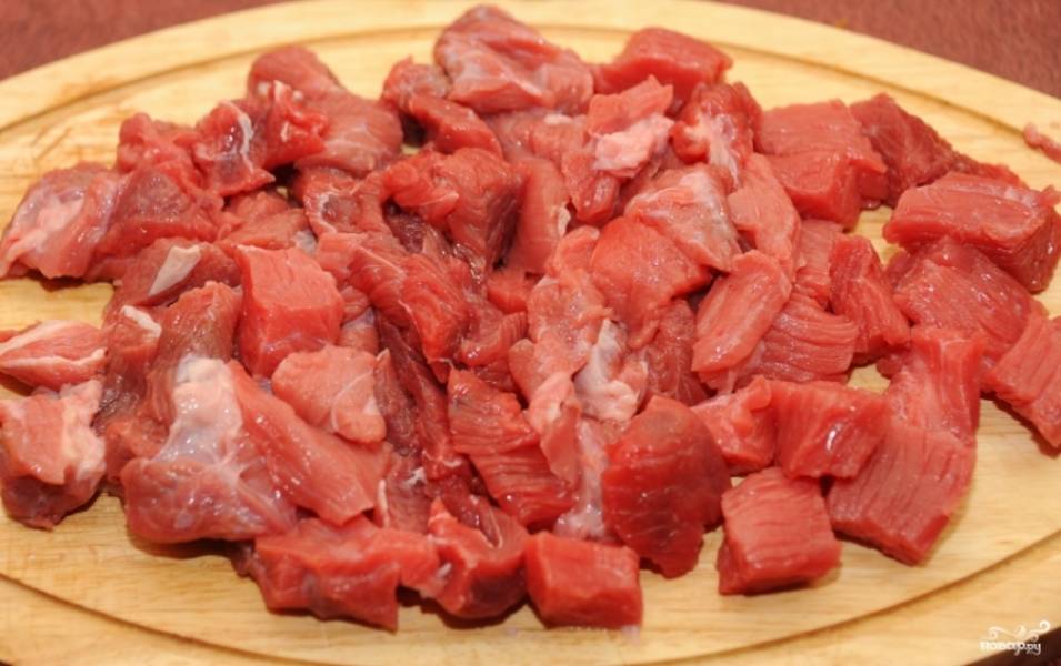 1.	Перед тем как приготовить говядину с курагой, расставьте все: мясо, зелень и специи на столе. Эти ингредиенты сейчас пригодятся. Мясо очистите от плевы, промойте под проточной водой, порежьте на небольшие кубики.