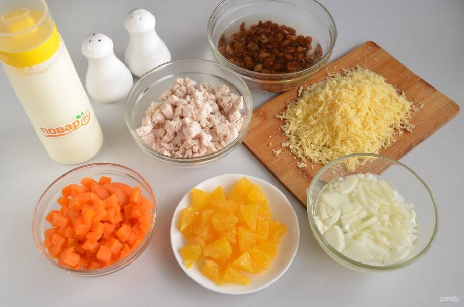 2. Изюм залейте кипятком, оставьте на 5 минут распариться, потом слейте полностью всю воду. Репчатый лук очистите, порежьте некрупно, сложите в пиалу и залейте уксусом с водой и сахаром, оставьте на 10-15 минут мариноваться. Порежьте филе и морковь. Сыр натрите на мелкой терке. Апельсин филетируйте и порежьте на кусочки.