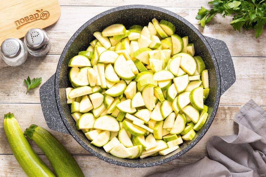 Кабачок нарежьте кружочками, затем каждый разрежьте на 2-4 части. Переложите в кастрюлю или сотейник с толстым дном.