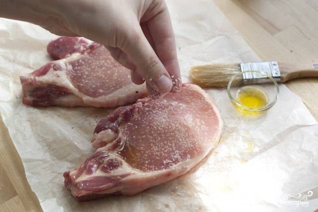 Свиные отбивные необходимо посолить и смазать оливковым маслом.
