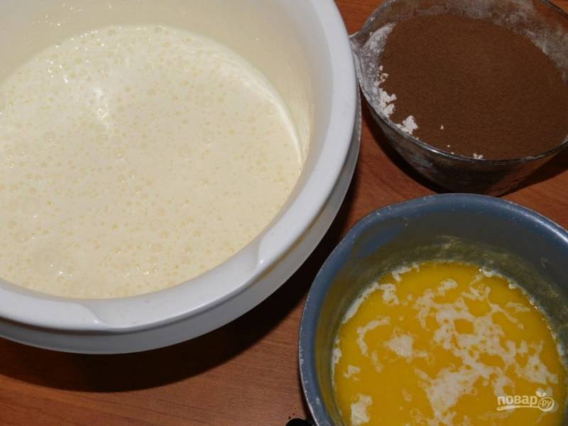 Для приготовления бисквита взбейте яйца с сахаром в пену. Аккуратно вмешайте муку, какао, соду и горячее молоко вместе со сливочным маслом.