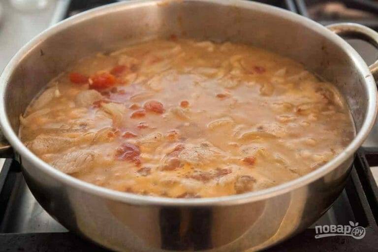 3.	Нарежьте мелко томаты, добавьте их в сковороду, а также добавьте черный молотый перец. Влейте воду, чтобы она слегка покрыла мясо, после закипания тушите на слабом огне полчаса. 