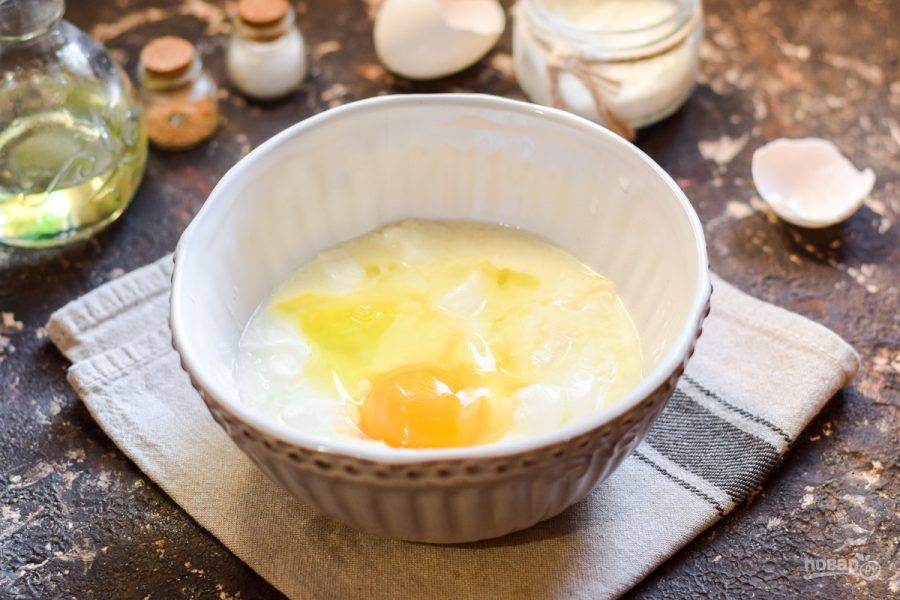 Кислую сметану переложите в миску, добавьте куриное яйцо.