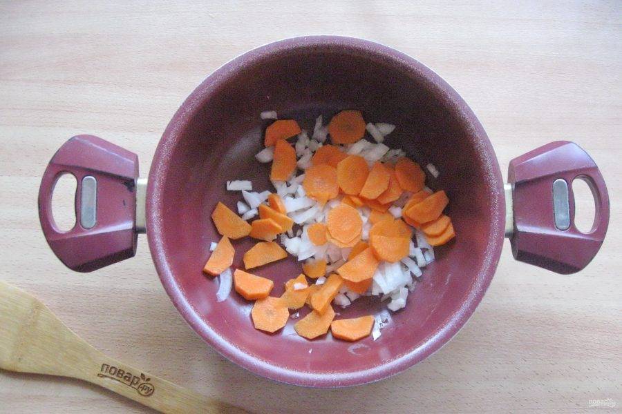 Морковь очистите, помойте и нарежьте. Добавьте к луку. Налейте подсолнечное масло и тушите овощи до мягкости лука.