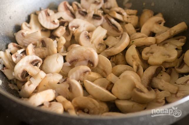 Разогрейте масло и обжарьте до золотистости лук с чесноком. Затем выложите грибы.