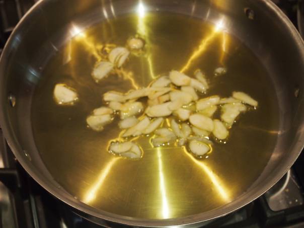 Чеснок и лук очистите, затем тонко нарежьте. Разогрейте масло в сковороде, обжаривайте лук с чесноком в течение пары минут, периодически помешивая.