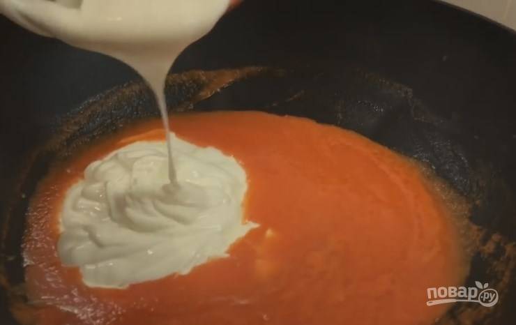 7. На раскаленную глубокую сковороду отправьте помидоры и 5 минут тушите их на среднем огне. Затем добавьте сметану и тушите еще 5 минут. 
