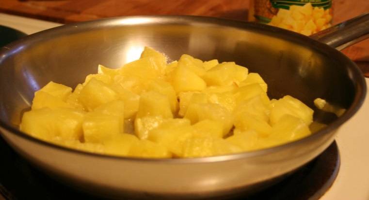 2. Выложите нарезанные ананасы на сковороду с высокими бортиками. Разогреть немного сковороду. 