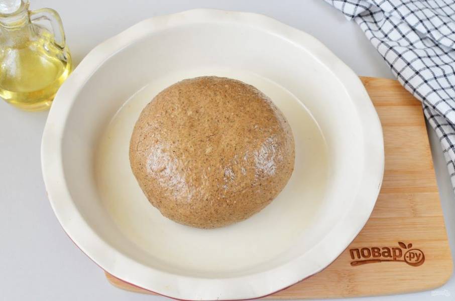 Форму в которой планируете печь хлеб, смажьте растительным маслом. Сформируйте булочку хлеба, ее тоже смажьте маслом. Накройте пленкой и оставьте на 30 минут.