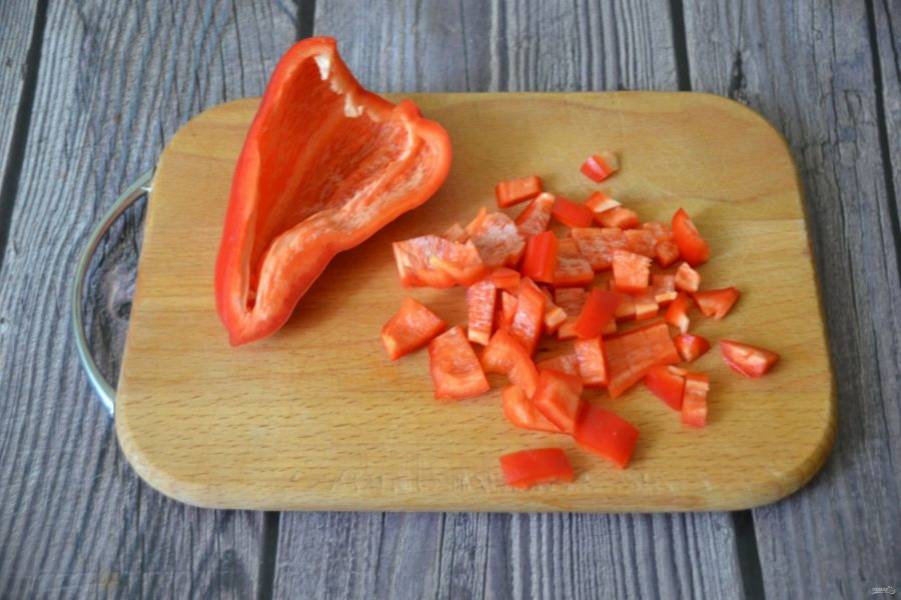 Порежьте красный перец небольшими кусочками, добавьте его в сотейник, когда мясо прокипит, примерно, через 10-15 минут.