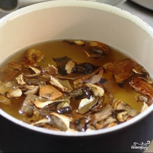 Сушеные белые грибы необходимо залить кипящей водой и оставить так на 1 час. Через час получившийся бульон отцеживаем (но не выливаем - он нам пригодится), грибы достаем и мелко нарезаем.