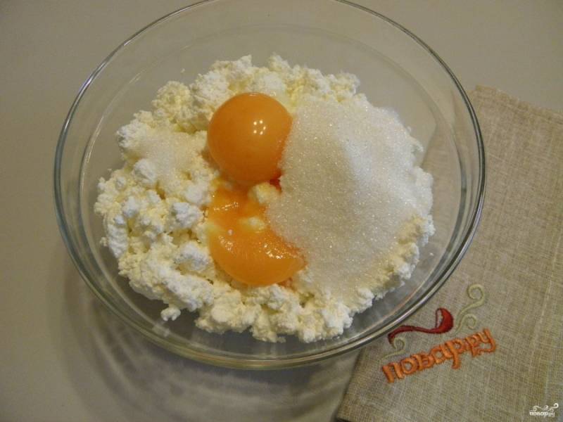 В творог добавьте желтки яиц, сахар, ванильный сахар. Перемешайте массу.
