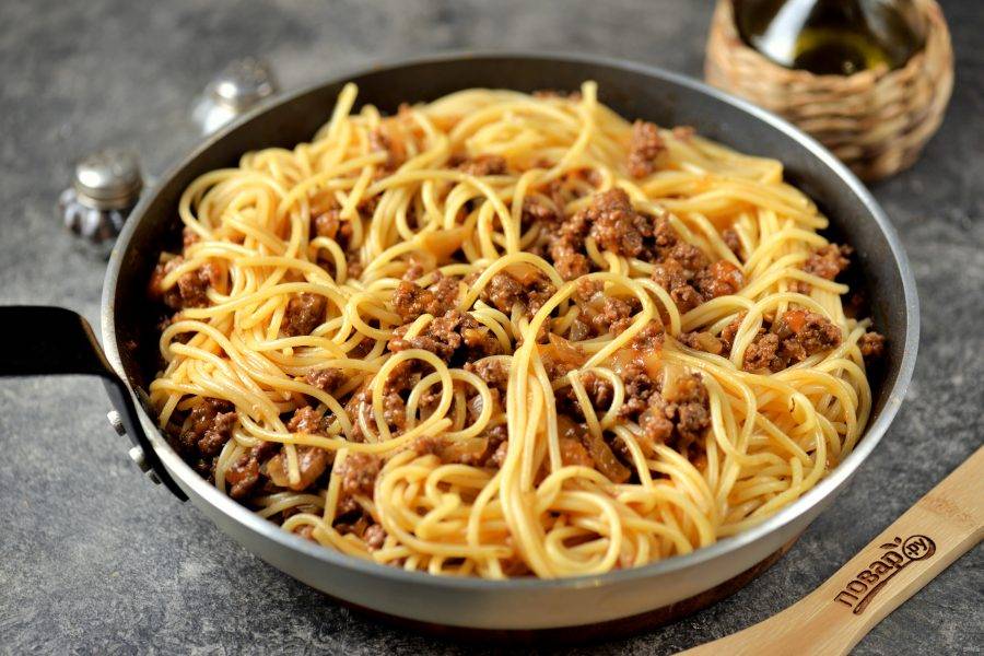 Переложите спагетти в соус болоньезе, перемешайте все аккуратно. 