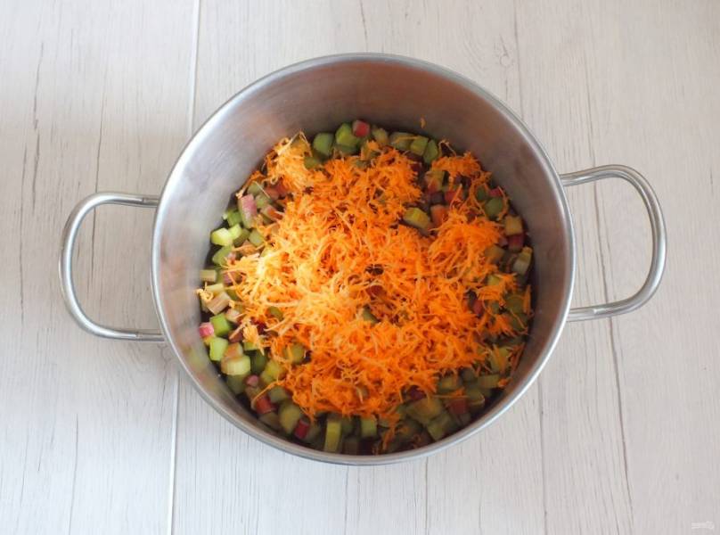 Натрите морковь на мелкой терке и добавьте в кастрюлю.