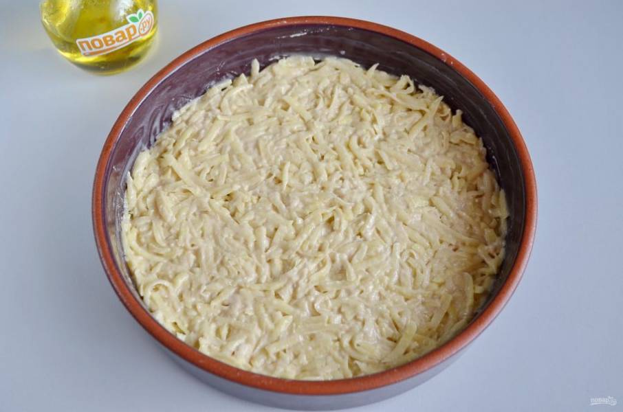 6. Антипригарную или керамическую форму смажьте хорошо растительным маслом. Половину картофельной массы распределите равномерно.