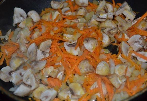 8. На сковороде разогреть небольшое количество растительного масла и выложить туда лук с морковью. Обжарить немного и добавить грибы. 