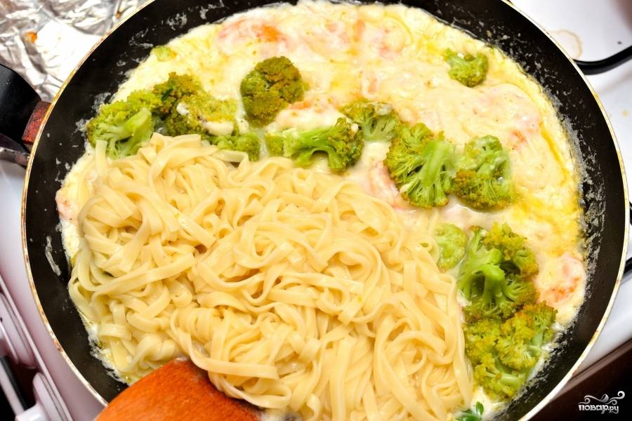 Параллельно сварите спагетти. Феттучинни подходят лучше всего, они и готовятся быстро. Спагетти выложите к креветкам в соусе. Так же положите сразу и брокколи.