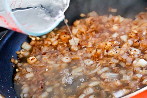 6. Добавить на сковороду немного бульона (можно в этот простой рецепт грибов под сливочным соусом и не использовать вовсе дополнительную жидкость, тогда соус будет более густым и насыщенным). 