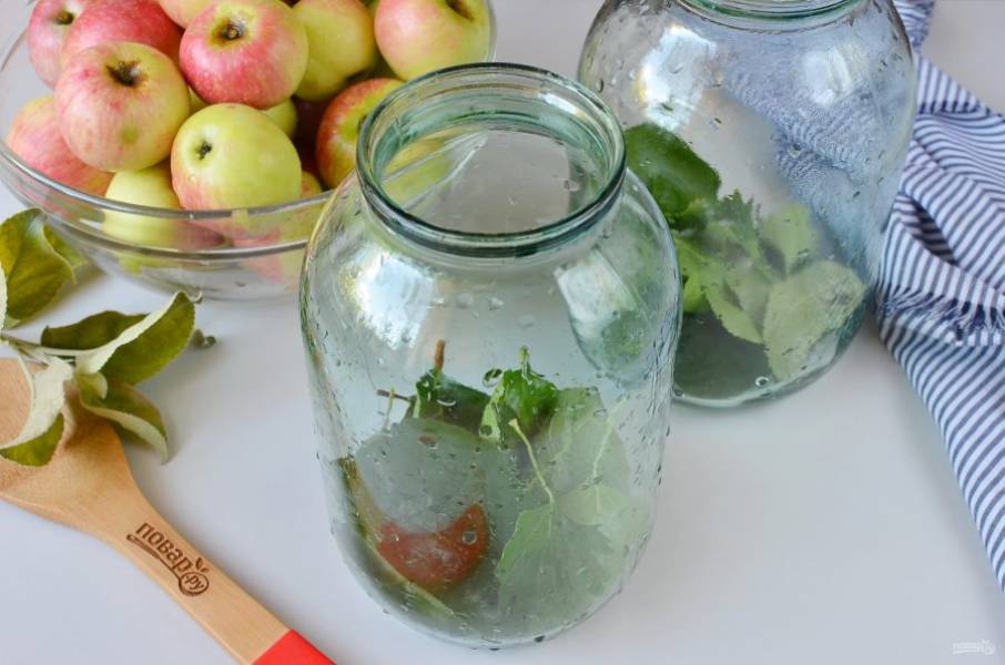 Вымойте хорошо банки, в которых будете мочить яблоки. На дно выложите половину листьев смородины и вишни.