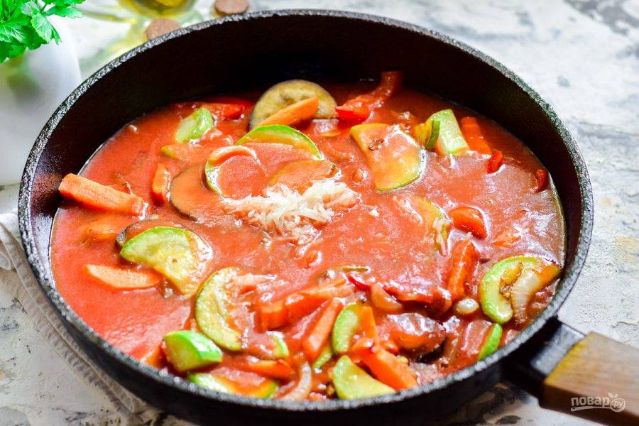 Влейте следом в сковороду томатный соус, добавьте пропущенный через пресс чеснок, соль и сахар.