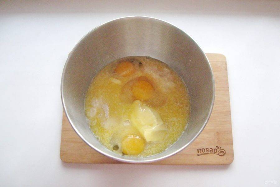 Разбейте яйца и выложите растопленное сливочное масло.